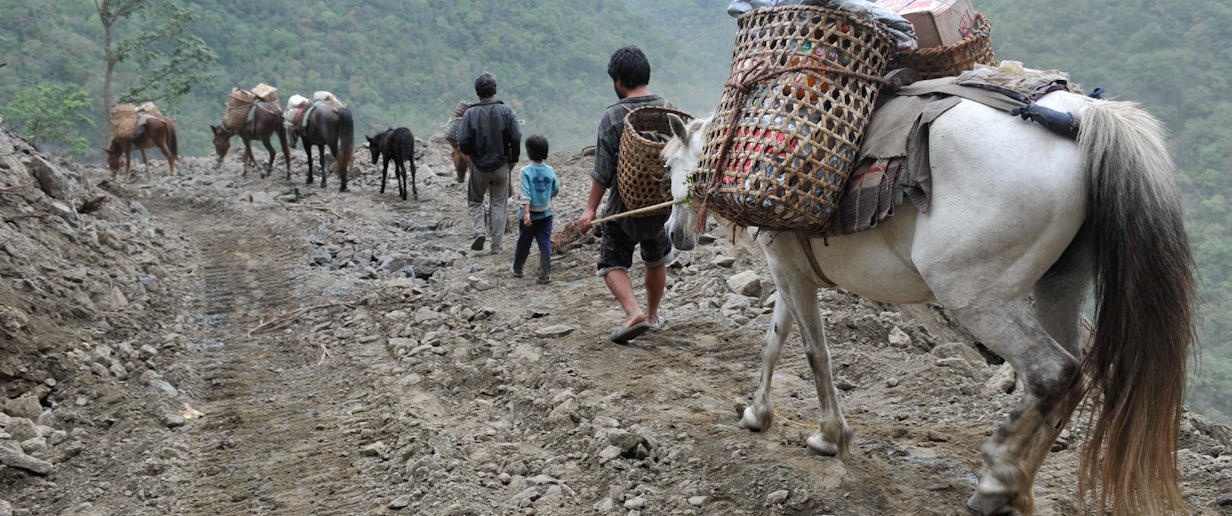 Villagers in Bhutan travel on remote dirt road with horses. Photo credit ADB 2010