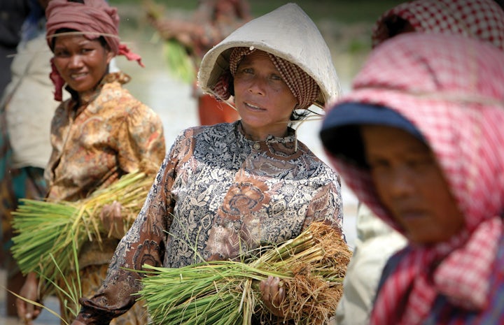 A group of women plant paddy rice seedlings in a field near sekong, laos. photo credit jim homes, dfat 2007