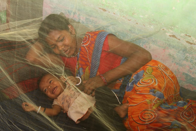 Mother and child under bed net in India. Photo credit: PMI 2016